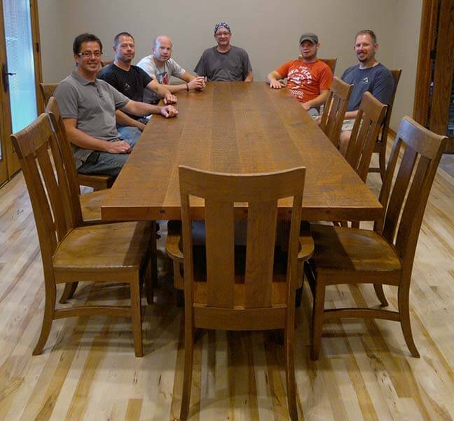 Sitting at the installed custom designed cherry wood table for 12 is Project Coordinator Jay Reichenbacher, Lead Aritsan John Miller, Artisan John Curry, Lead Artisan Tom Bloxham, Artisan Alex Schlepphorst, and Production Manager Jason Anderson