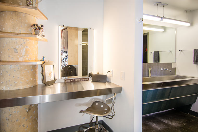 Concrete column with floating shelves in makeup area of bathroom in downtown Des Moines loft remodeled by Silent Rivers