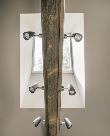 Automatic skylight above barn board beam with spotlights in master bathroom by designer and remodeler Silent Rivers of Des Moines, Iowa