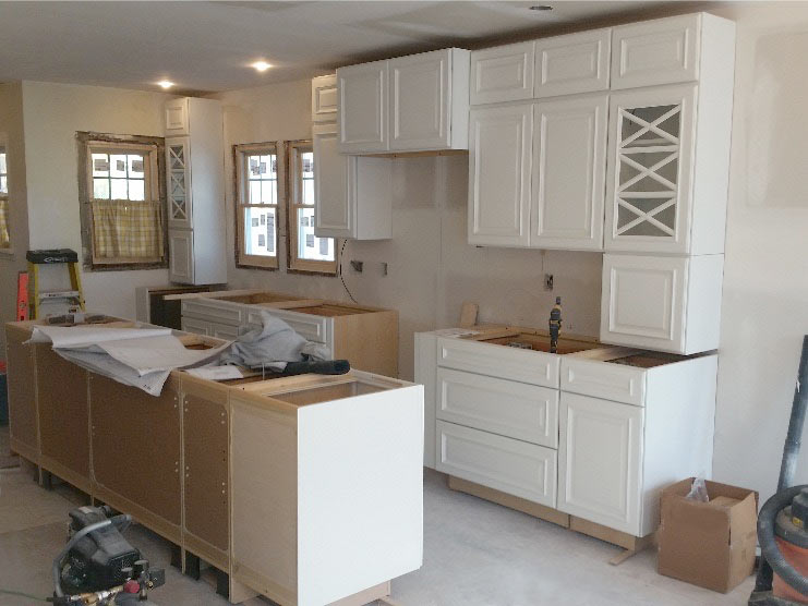 white kitchen cabinets installed, drywall up in kitchen addition to Des Moines bungalow by Silent Rivers