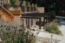 Contemporary steel arbor is softened by tall grasses and landscaping.