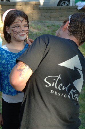 A member of the Silent Rivers team makes a Jazz in July event even more enjoyable for a young attendee.