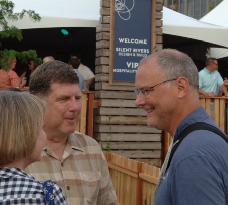 Stephen King, Executive Director of the Des Moines Arts Festival stops by Neymaster Law Firm gathering and visits with Mary Cownie.