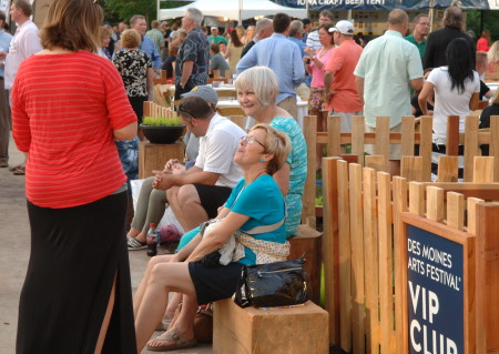 Des Moines Arts Festival attendees rest on solid blocks of sycamore, listening to The 10,000 Maniacs.