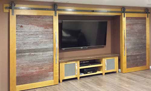 Reclaimed barn wood doors on an entertainment center design by Silent Rivers Design+Build