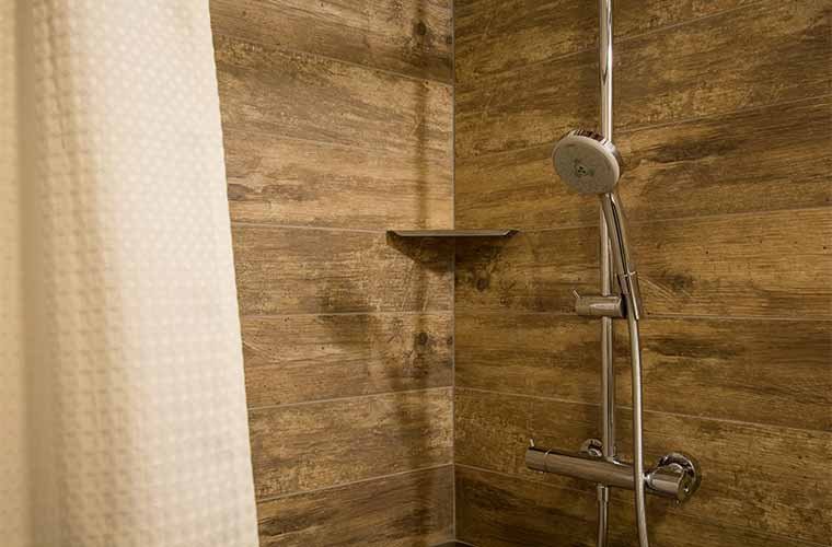 Tile resembling concrete and weathered wood in a downtown Des Moines loft bathroom remodel by Silent Rivers