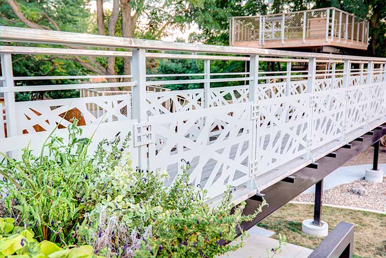 Angles in metal panels of catwalk bridge to grown up treehouse play structure in Johnston Iowa designed by Silent Rivers