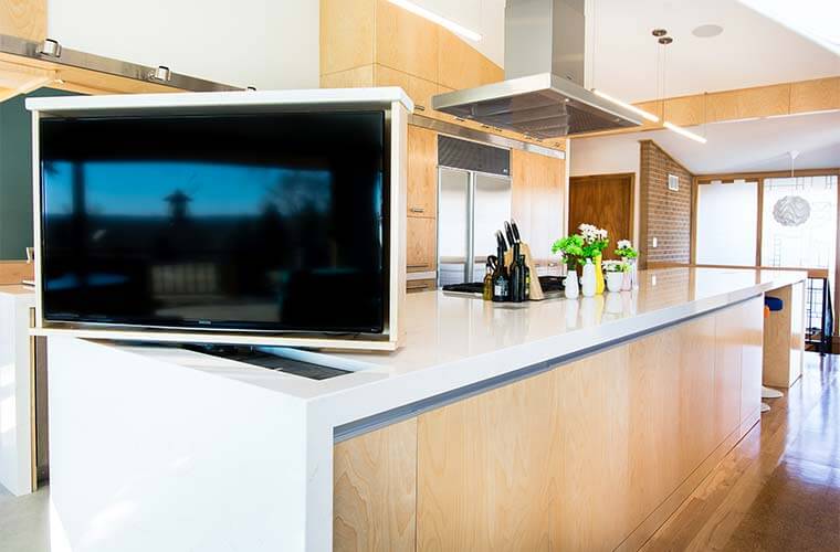 Johnston Iowa contemporary midcentury kitchen remodel by Silent Rivers, showing hidden TV in lifted position from the countertop