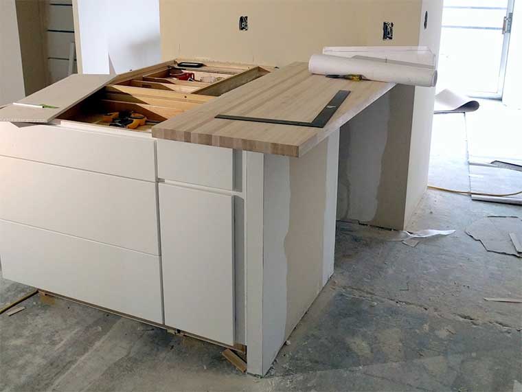 Pre-manufactured Wellborn Cabinets in a modern flush slab face being installed in a Des Moines condo by Silent Rivers