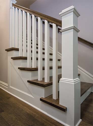 Stairway designed by Silent Rivers with stair railing to match the original farmhouse style of this historic Des Moines home.