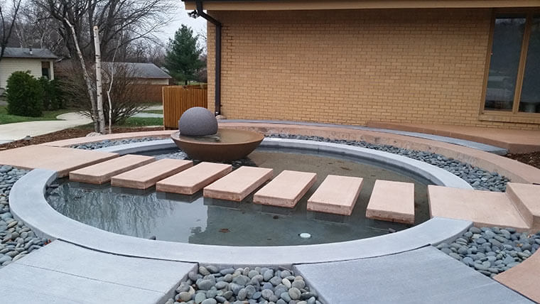 Water feature with stepping stones and a water bowl fountain at a Johnston, Iowa home