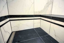 Shower with black and white marble tile in Des Moines art deco bathroom remodeled by Silent Rivers