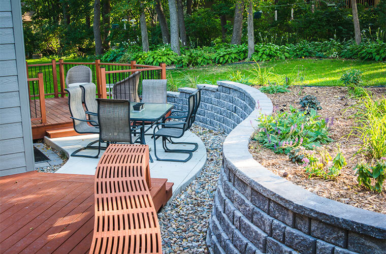 Outdoor patio and landscaping in Des Moines with curved retaining wall by Silent Rivers