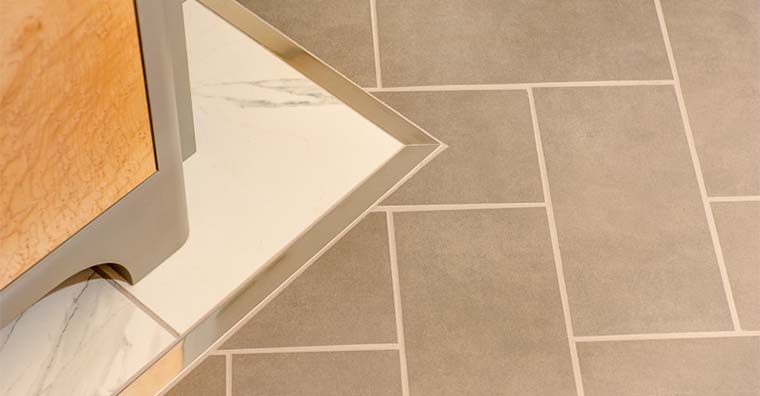 Tile floor in contemporary bathroom remodel by Silent Rivers uses metal inlay to separate two kinds of floor tile