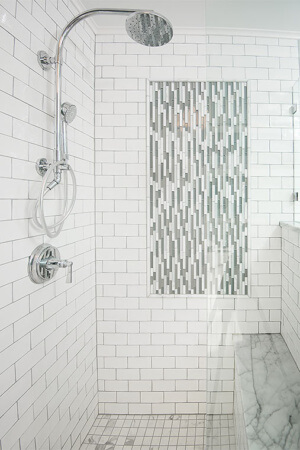 Des Moines, Iowa craftsman bathroom remodel includes tiled shower with glass mosaic inset and marble bench designed by Silent Rivers