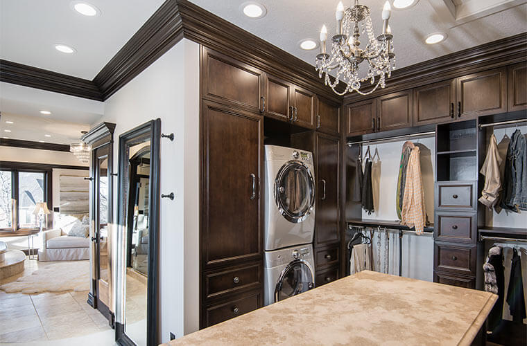 Urbandale-Iowa-luxurious-master-closet-by-Silent-Rivers with travertine counters, crystal chandelier, stacked washer and dryer