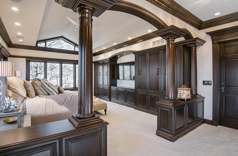 Urbandale-Iowa-luxurious-traditional-master-bedroom-by-Silent-Rivers with fluted cherry columns in a custom colonnade with curved wood moldings