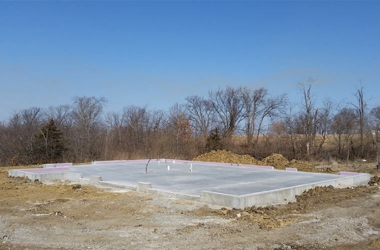 Concrete slab is poured on new house designed and built by Silent Rivers in Iowa