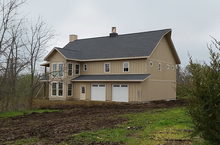 Siding and roofing complete on dried-in new house by Iowa homebuilder Silent Rivers Design+Build