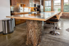 Natural tree stump supports a long kitchen island in a downtown Des Moines loft remodel by Silent Rivers