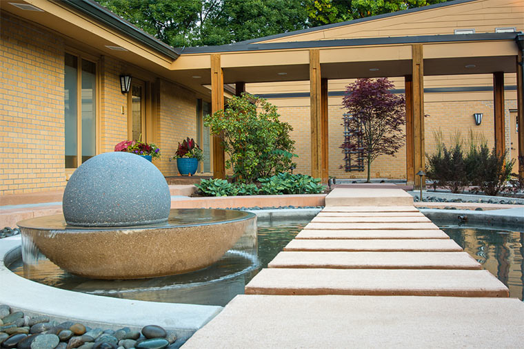 Water feature ball and spilling basin in front courtyard of Johnston, Iowa home given new look by Silent Rivers
