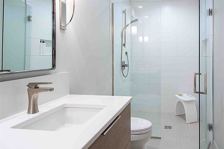 Vanity and shower in a white modern bathroom remodel by Silent Rivers Des Moines feels open, peaceful and spa like