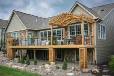 Distinctive deck design with curved pergola and cable railing designed and built by Silent Rivers, Des Moines, Iowa golf course