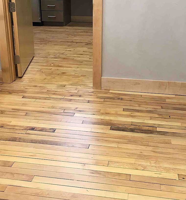 Beautifully finished reclaimed wood floor in historic Green & Main building by Silent Rivers features original maple floor and salvaged floor from closed Cambria, Iowa school