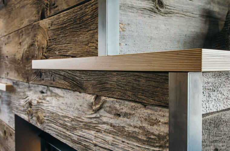 gas fireplace clad with barn board, raw steel, birch shelves in downtown Des Moines loft by Silent Rivers Design+Build