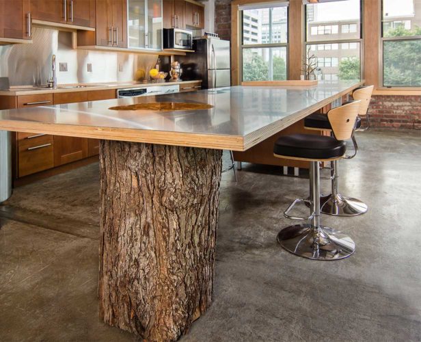 Downtown Des Moines loft remodel features a 16 foot kitchen island with natural raw maple tree stump as a support, design and built by Silent Rivers
