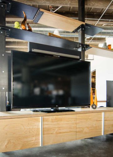 Custom entertainment center in downtown loft serves as room divider made of Baltic birch and and raw steel with floating cabinet to hide TV and stereo components, Silent Rivers, Des Moines