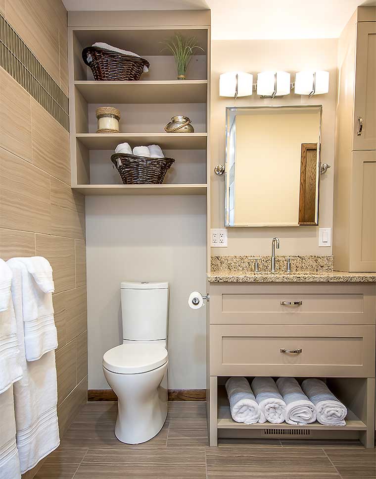 Contemporary bathroom remodeled by Silent Rivers features custom shelving over toilet, tilt mirrors, custom vanity, extra storage and a bold new look from its former 1980s bathroom style in this Des Moines, Iowa home