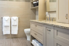 A former 1980s bathroom remodeled to contemporary style by Silent Rivers Des Moines features linear tile and custom cabinet vanity