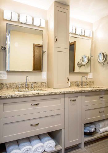 Custom double vanity with tall medicine cabinet, tilt mirror, granite countertop, linear ceramic floor tile in 1980s bathroom remodel by Silent Rivers, Des Moines