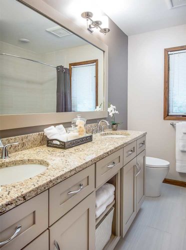 1980s hallway bathroom remodel by Silent Rivers, Des Moines features a double vanity, large framed mirror