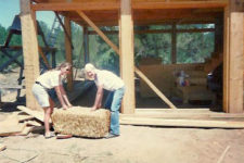 Molly Spain and her mother JoAn van Balen carry the first straw bale as they create their sustainable, off-the-grid strawbale house in New Mexico