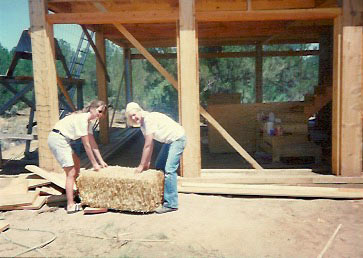 Molly Spain and her mother JoAn van Balen carry the first straw bale as they create their sustainable, off-the-grid strawbale house in New Mexico
