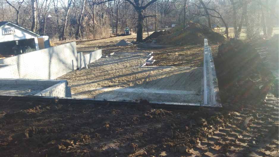 backfilling after concrete walls and exterior drainage are complete for custom new home in Des Moines designed and built by Silent Rivers