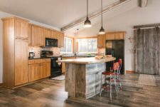 Rustic kitchen with curved island designed with recycled and upcycled metal and barn wood in central Iowa designed and built by Silent Rivers