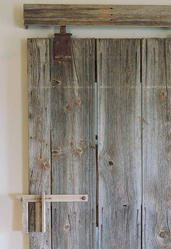 salvaged barn door in family room of rustic home redesigned by Silent Rivers in central Iowa for a rural Iowa retreat