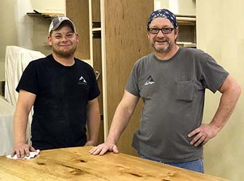 Alex Schlepphorst and Tom Bloxham in the Silent Rivers woodshop built the custom table from maple beams.