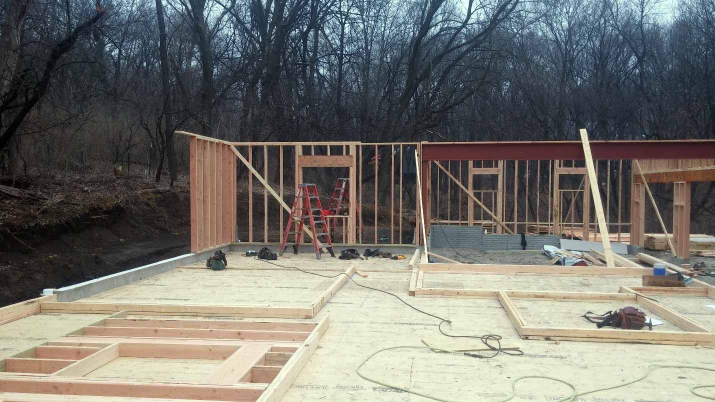 New custom home designed and being built by Silent Rivers of Des Moines, Iowa partially framed showing garage and subfloor