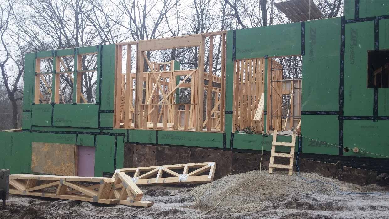 New custom home designed and being built by Silent Rivers of Des Moines, Iowa partially framed and ready for trusses