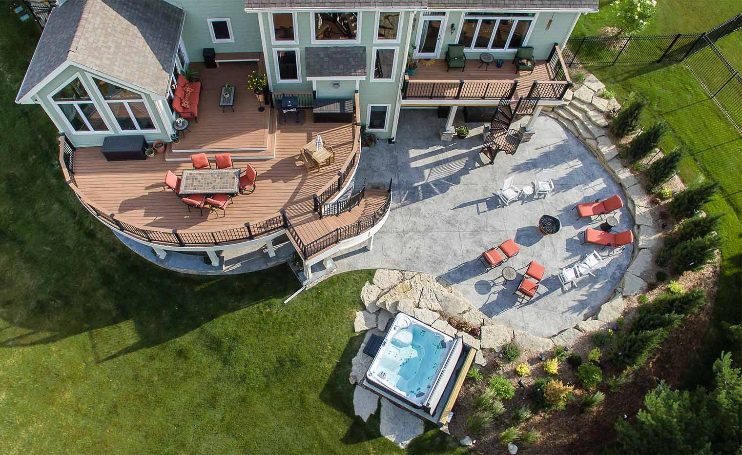 Aerial view of Urbandale backyard renovation_entertaining area with deck, patio, spa, curved stairs designed and built by Silent Rivers of Des Moines, Iowa