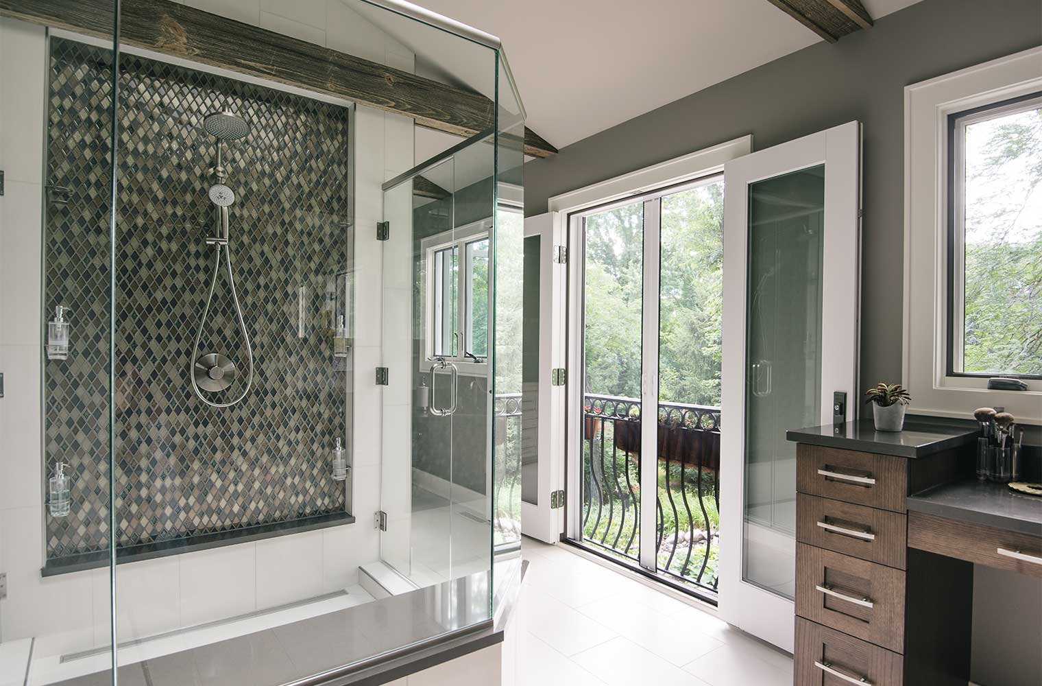 Juliet balcony in contemporary master bathroom with central glass enclosed shower offers backyard views by designer and remodeler Silent Rivers of Des Moines, Iowa