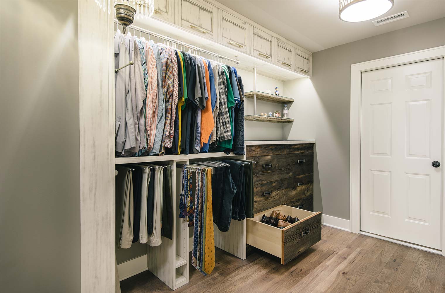 his closet features barn wood drawer fronts, pull out pant and tie racks, shoe drawers in master suite by designer and remodeler Silent Rivers of Des Moines, Iowa
