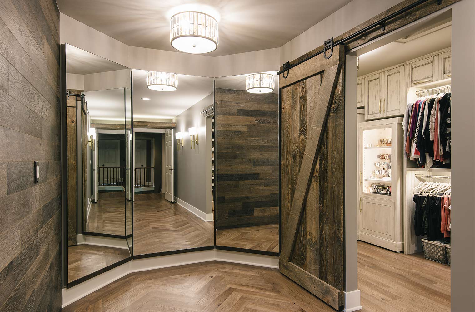 Three-way dressing room style mirror next to lavish walk-in his and her closet in master suite by designer and remodeler Silent Rivers of Des Moines, Iowa