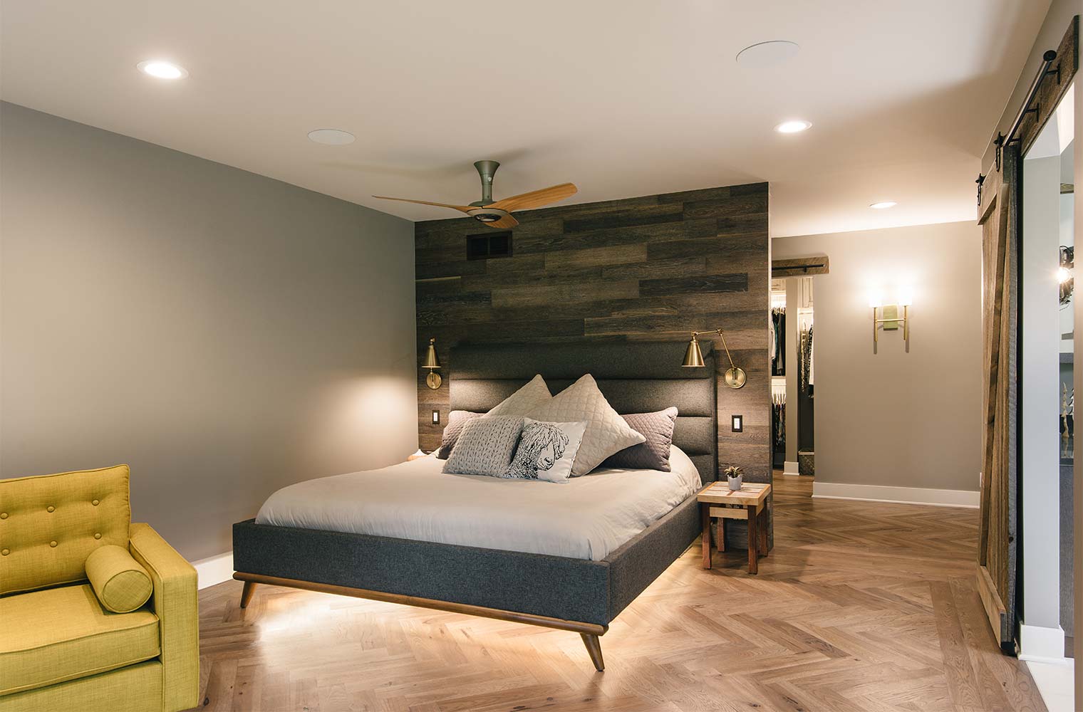 Funky contemporary master suite bedroom with barn board wall, lighted platform bed and herringbone wood floor by designer and remodeler Silent Rivers of Des Moines