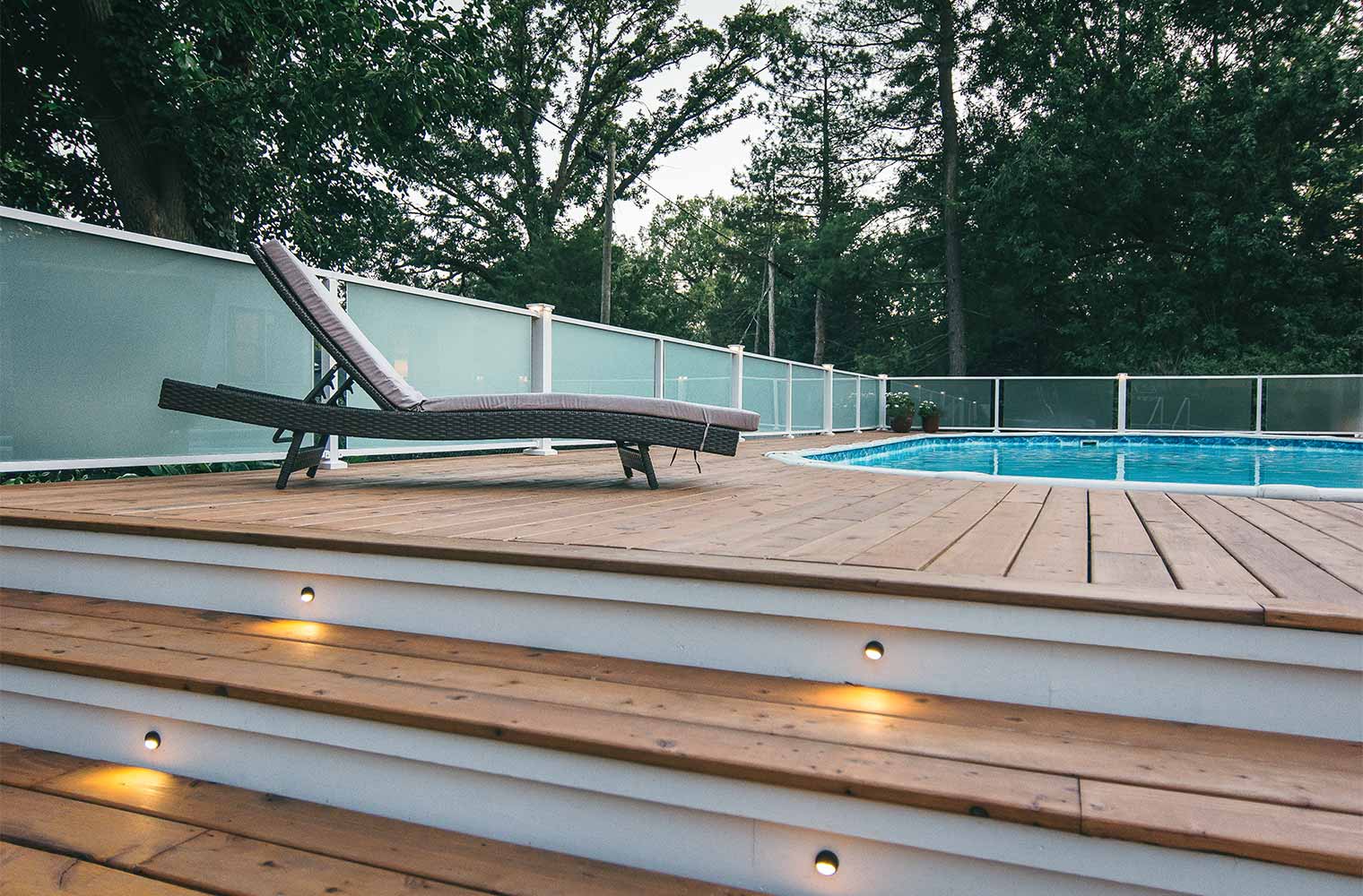 cedar pool decking and frosted glass panels for railing on midcentury ranch home in Des Moines, Iowa by remodeler Silent Rivers