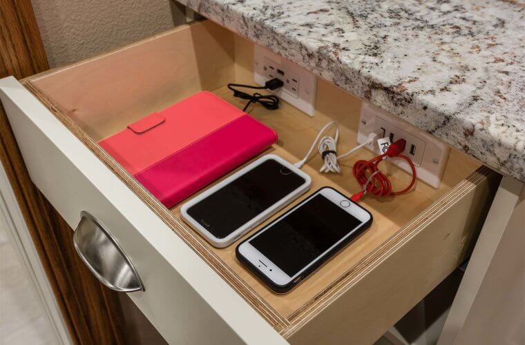 Hidden charging station for phones, tablets and digital devices in a drawer in kitchen and pantry area by remodeler Silent Rivers of Des Moines, Iowa